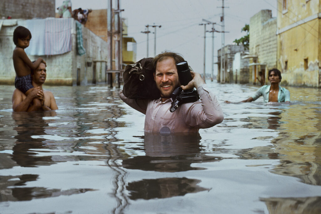 MCCURRY THE PURSUIT OF COLOR. Steve McCurry wades through water. Monsoons