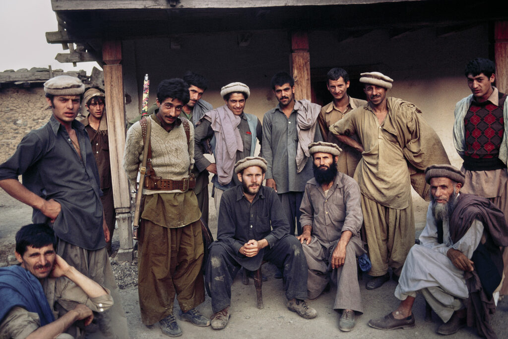 Photographer, Steve McCurry, poses with a group of Afghani men.